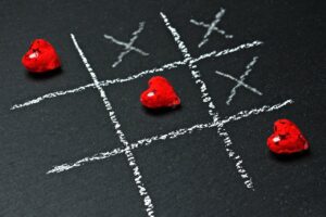 Corazones rojos forman línea diagonal en juego de gato