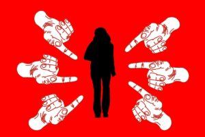 Sombra de mujer señalada por muchas manos